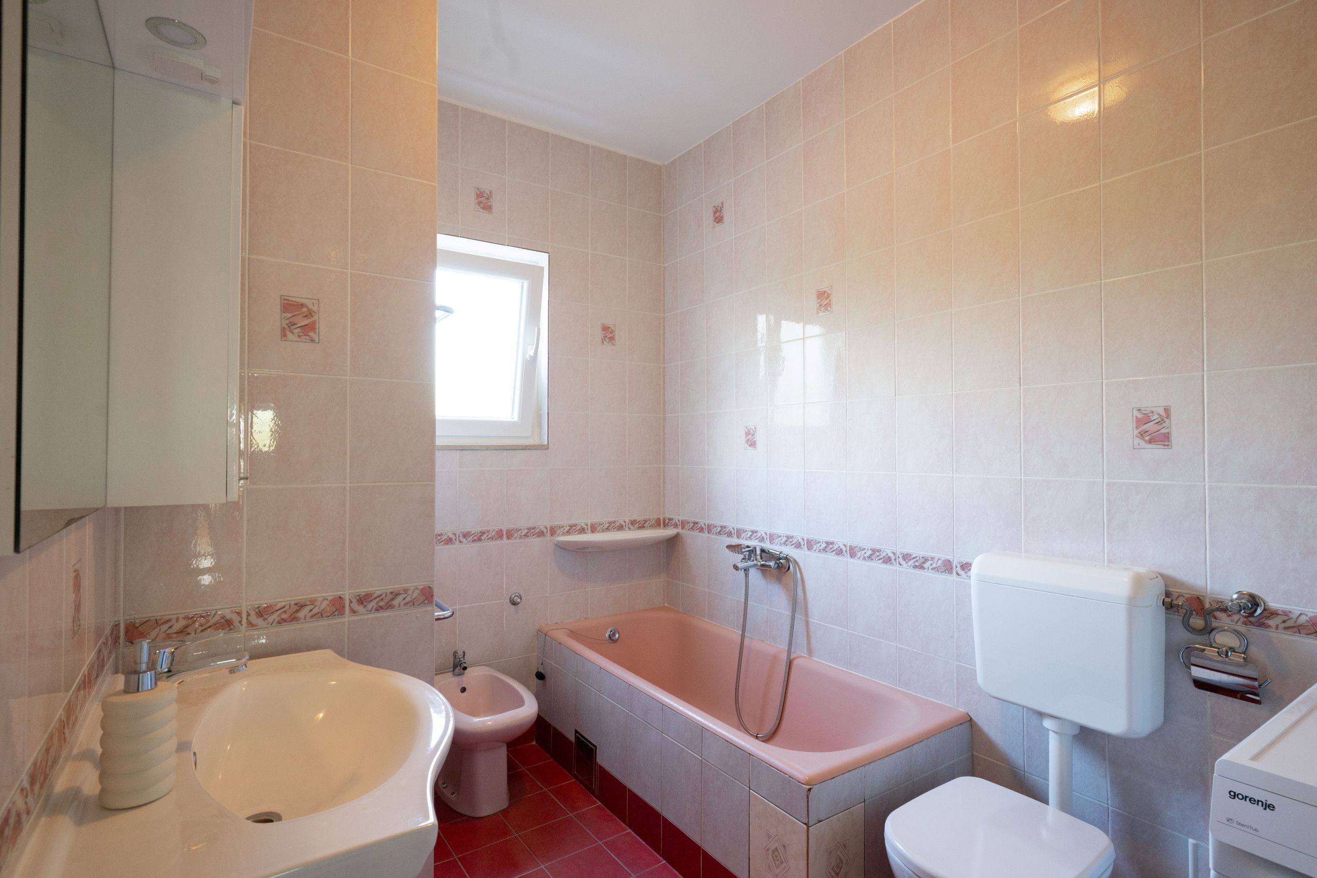 Une salle de bain équipée d’une baignoire, de toilettes, d’un bidet et d’un lavabo.