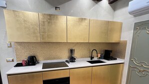 Une cuisine moderne avec des meubles de couleur or, un pare-feu en carreaux et un four encastré.