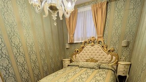 Une chambre à coucher avec un grand lit, une tête de lit décorée et un lustre.