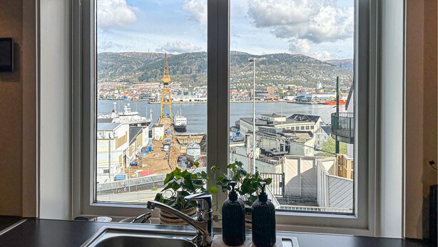 Eine Küche mit einem großen Fenster mit Blick auf einen Hafen und eine Stadtlandschaft.