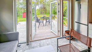 A room with a sliding glass door leading to an outdoor deck with a table and chairs. - 2 bedroom awesome home in Visby (Visby)