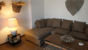 A living room with a sofa, a coffee table, a lamp, and decorative baskets.