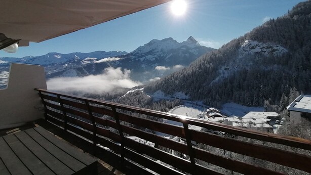 A balcony with a wooden railing overlooking a mountainous landscape with snow-covered peaks and a clear sky. - 3-room apartment for 7 people, renovated, sunny balcony (Pra-Loup)