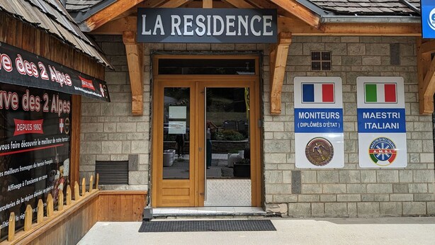 A building with a sign reading "LA RESIDENCE" and two signs indicating "MONITEURS (DIPLOMES DE L'ETAT)" and "MAESTRI ITALIANI". - Bright apartment near slopes, pets allowed (Les Deux Alpes)
