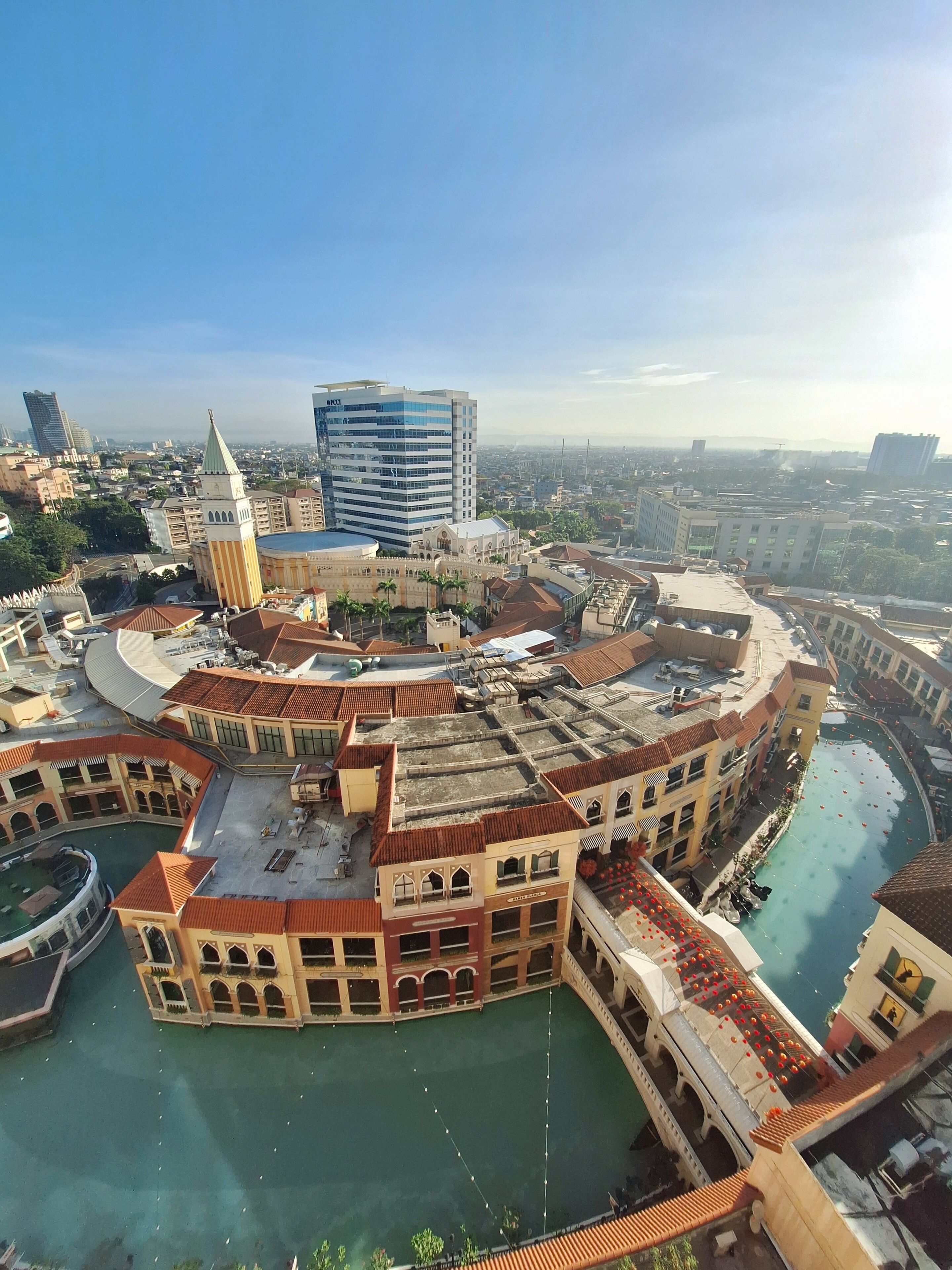 A historic building complex with a central courtyard, a large fountain, and a modern high-rise building in the background.
