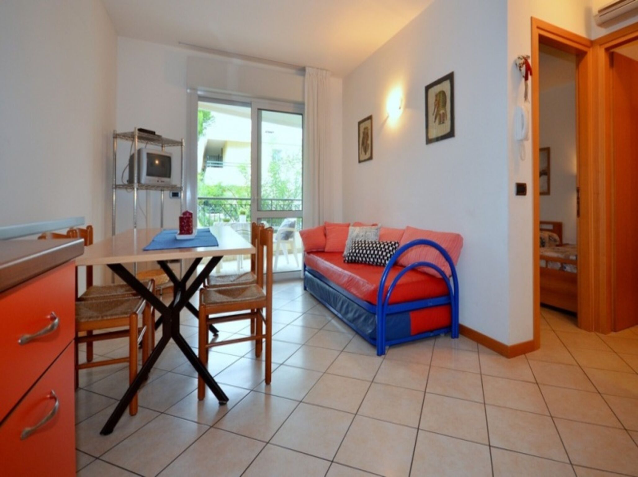 Une cuisine moderne avec une table et des chaises, un canapé avec une structure bleue et un balcon avec vue.