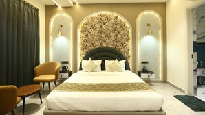 A modern hotel room with a large bed, a chair, a desk, and a shower area. - HOTEL ELEGANCE (Amritsar)