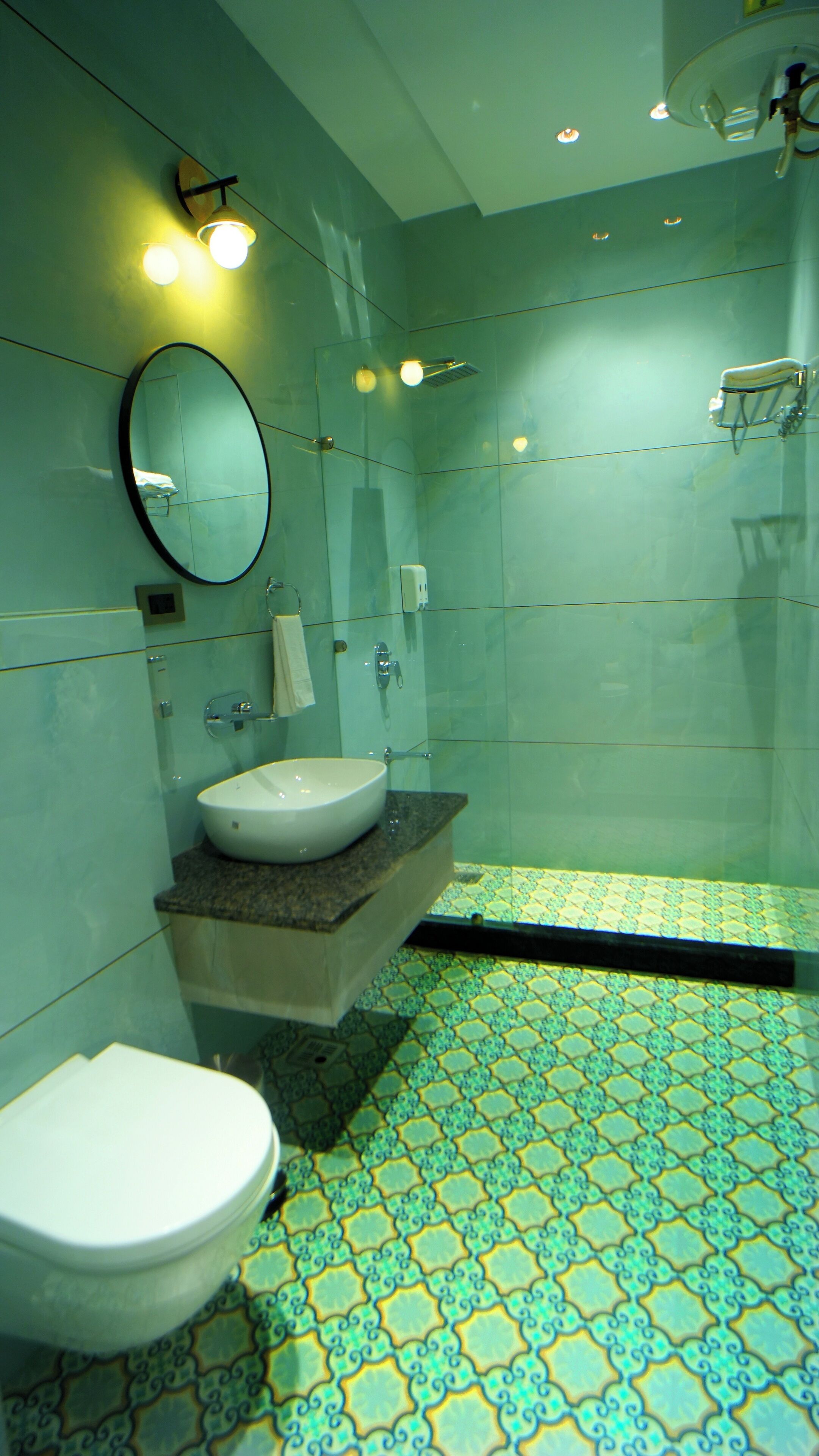 A bathroom with a white sink, a mirror, a toilet, and a shower area.
