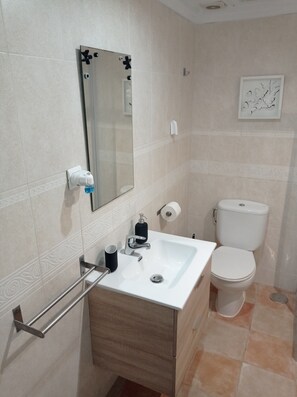 A bathroom with a white sink, a mirror, a toilet, and a towel rack. - Beachfront studio (Calahonda)