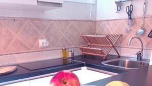 A kitchen counter with a fruit bowl containing apples, bananas, and an orange. - Beachfront studio (Calahonda)