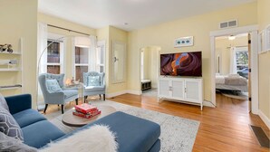 A modern living room with a sofa, armchairs, a coffee table, and a TV. - Spacious Old Town Home Walk to Dining & Culture! (Fort Collins)