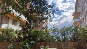An outdoor patio with a round table and two chairs, a potted plant, and a glass of wine. - Island Circobueno - 5609 (Arnuero)