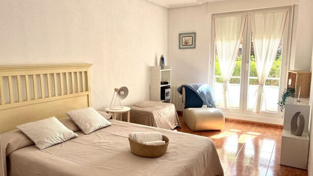 A hotel room with two beds, a small table, a chair, a bookshelf, and a window with curtains. - Island Circobueno - 5609 (Arnuero)