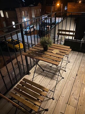 Relax in this outdoor seating area with a table and benches, surrounded by a railing.