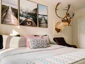 Relax in this serene bedroom with a large bed, a comfortable leather chair, and scenic lake views.
