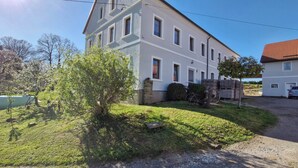 A two-story building with a white facade and a red-tiled roof. - Vacation apartment Schwalbennest (Großschirma)