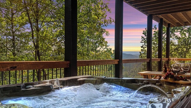 Un jacuzzi con maderas, una mesa con copas de vino y uvas.