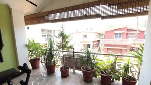 A balcony with potted plants and a gym area. - Coorg Shell (Madikeri)