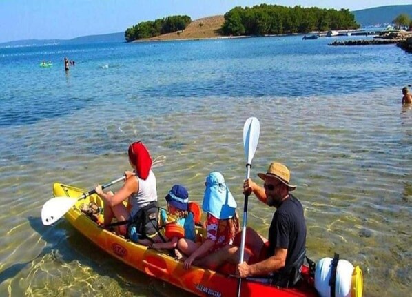 Un groupe de personnes dans un canoë sur une étendue d’eau calme, avec une côte visible au loin.