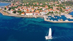 An aerial view of a coastal town with houses, a marina, and a sailboat. - Three Bedroom House With Terrace (Pasman)
