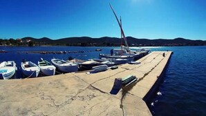 A pier with boats docked, a clear sky, and a mountainous backdrop. - Three Bedroom House With Terrace (Pasman)