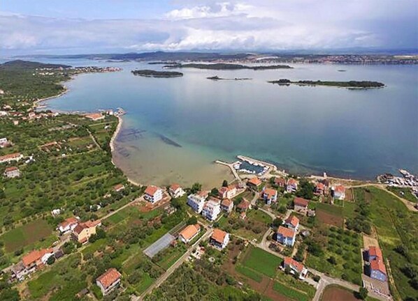 An aerial view of a coastal town with houses, a beach, and a marina. - Three Bedroom House With Terrace (Pasman)