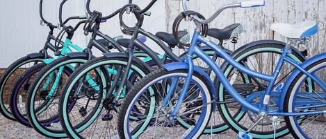 Varias bicicletas estacionadas junto a una cerca blanca.