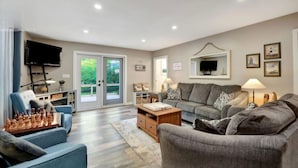 A living room with a sofa, a coffee table, a TV, and a chessboard. - Peninsula Perch: Water & Trails (Wiarton)