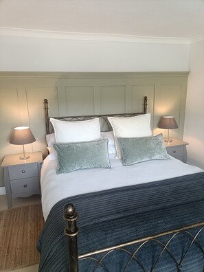 A neatly made bed with a headboard, two bedside tables with lamps, and a textured rug. - Entire 3 bed Yorkshire Cottage, Harrogate.  (Harrogate)