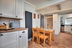 Enjoy a home-cooked meal at the dining table for two, equipped with a bread maker for added convenience.