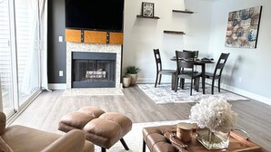 Un salon moderne doté d’une cheminée, d’un coin salon et d’un espace repas.