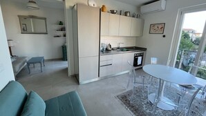Una cocina moderna con comedor, sofá y vistas al exterior.