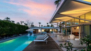 A modern outdoor pool area with lounge chairs and a wooden deck. - Luxury 4-bedroom Home With Pool Spa Stunning Mountain Views (Palm Springs)