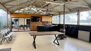 Un espace intérieur doté d’un haut plafond, d’une table centrale et de plusieurs coins salon.