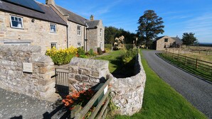A stone building with a sign welcoming visitors to Carrav. - Two self catering holiday homes that sleeps 14 guests  in 7 bedrooms (Hexham)