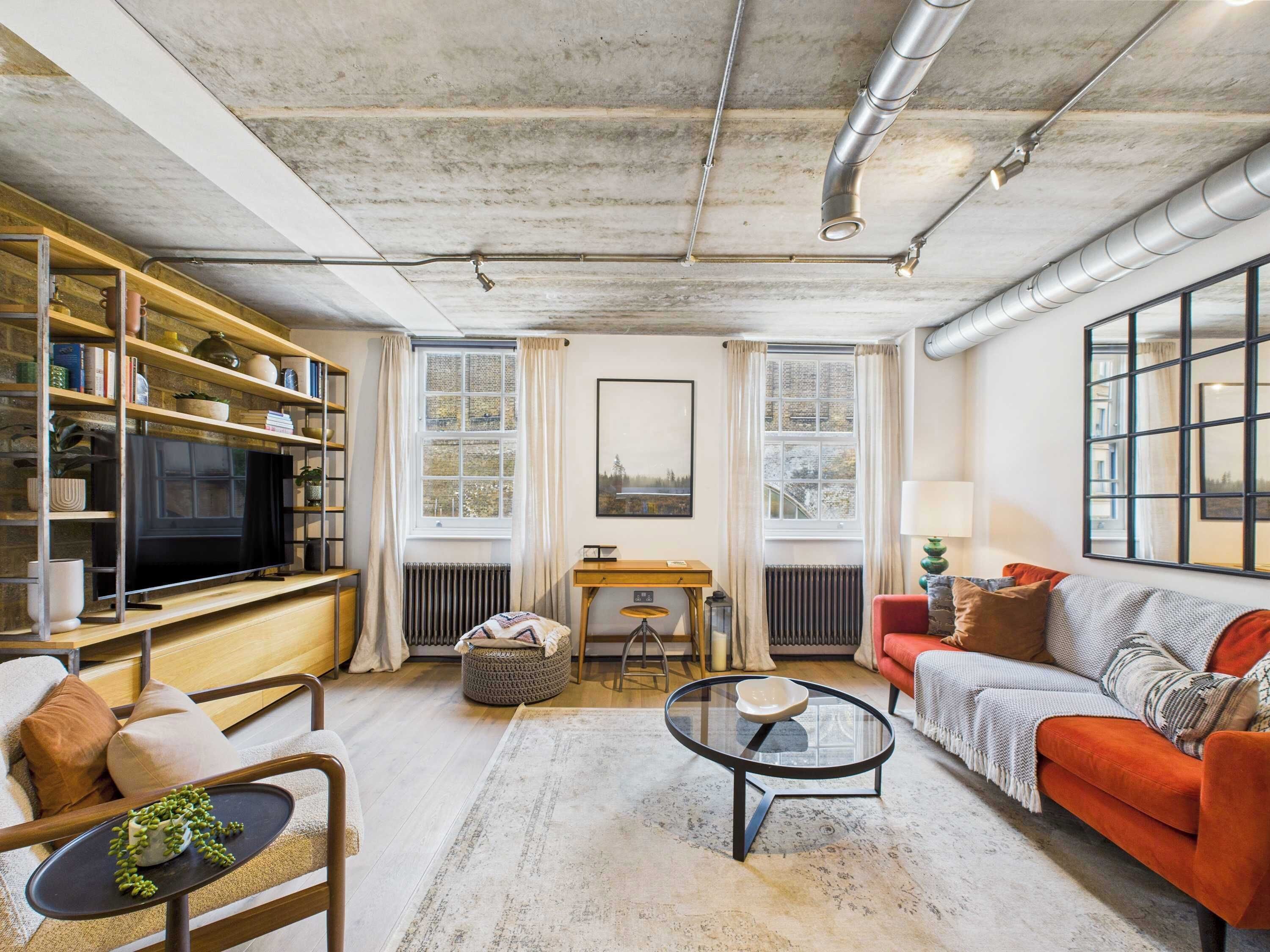 A living room with a television, bookshelves, a sofa, and a coffee table.