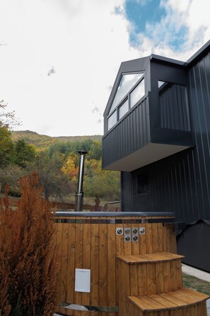 A modern building with a wooden deck and a hot tub.