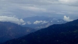 A mountainous landscape with clouds between the peaks. - Backpackers Hostel  (Darjeeling)