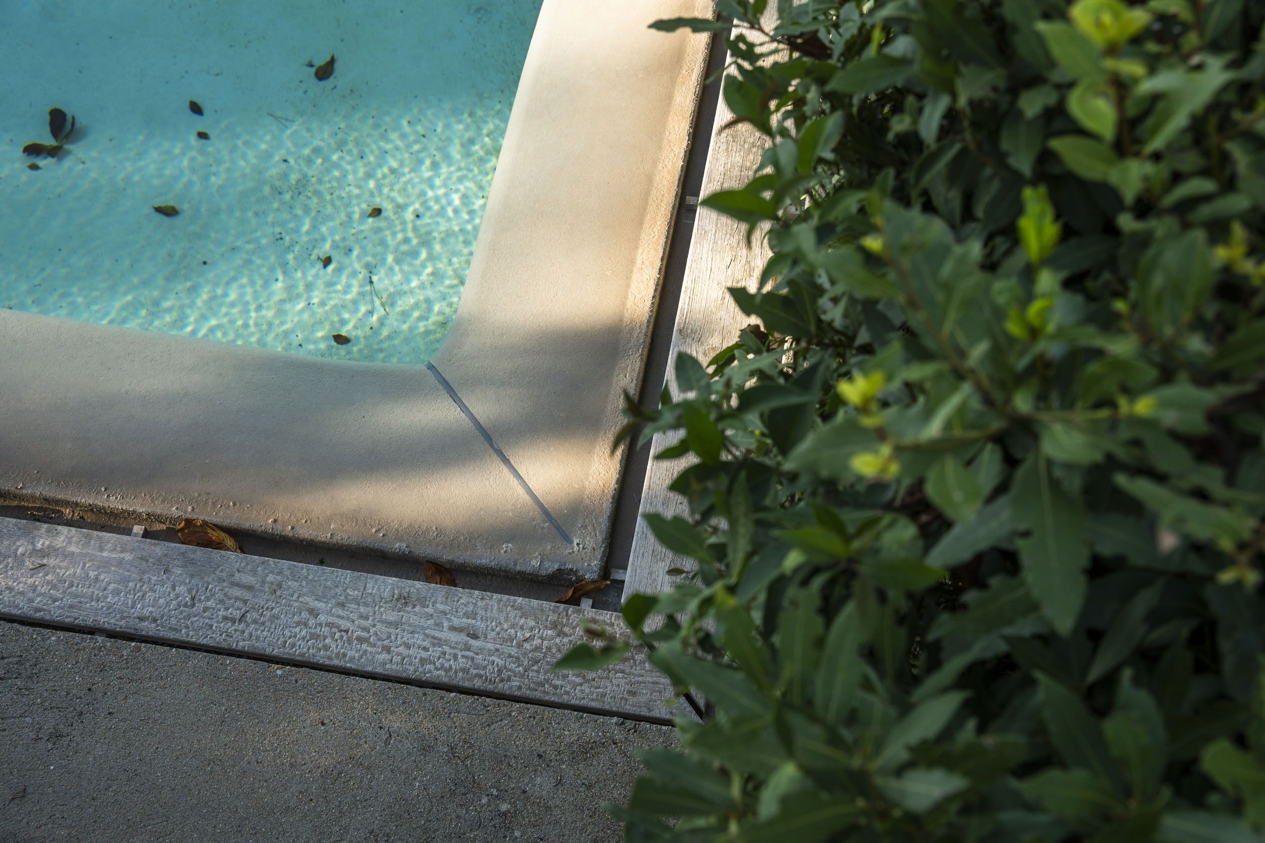 Una piscina con agua cristalina y borde de hormigón.
