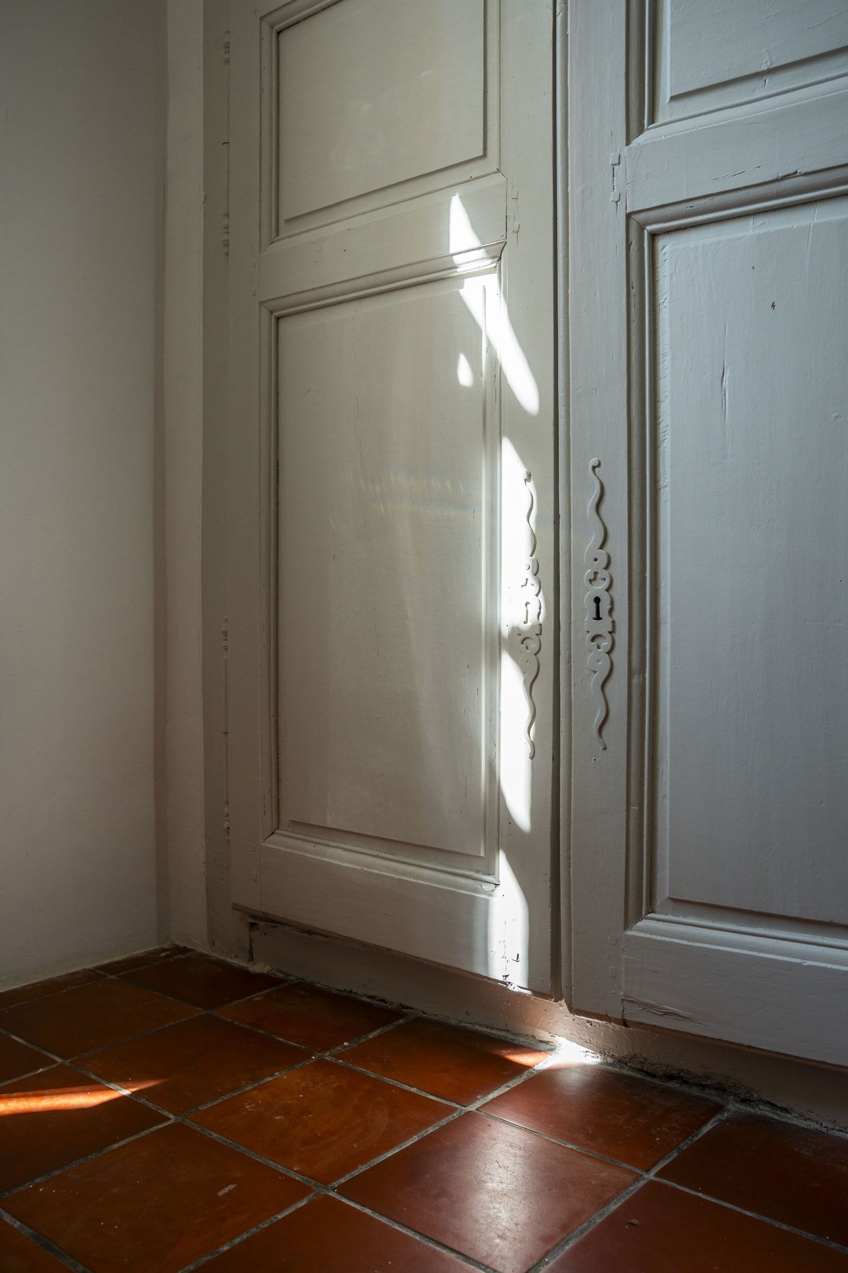 A white door with a decorative handle and a small number above it.