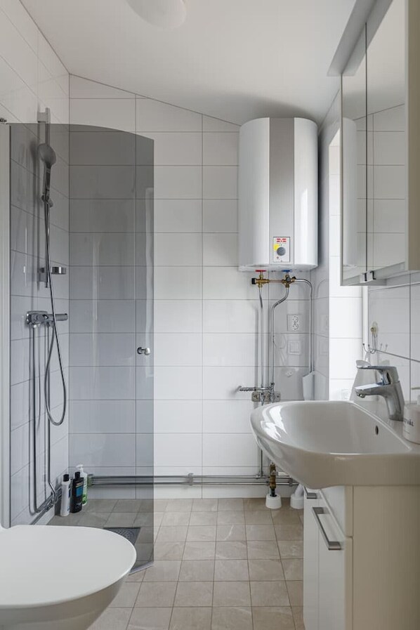 Une salle de bain moderne équipée d’une douche, de toilettes et d’un lavabo.