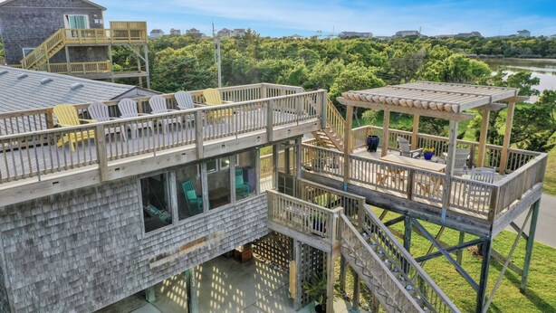 A multi-level wooden deck with outdoor seating and a view of a lake. - Relaxing family and dog friendly getaway located in Hatteras (Hatteras)