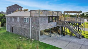 Une maison à deux étages dotée d’une terrasse et d’un patio couvert.