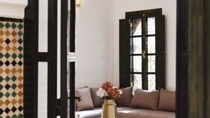 Un salon avec un canapé beige, une table basse en bois et un vase rempli de fleurs.