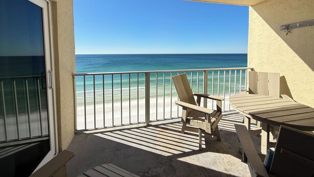Ein Balkon mit Blick auf Strand und Meer.