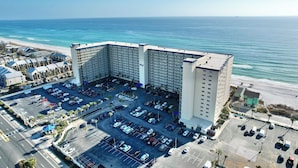 Un hotel grande con estacionamiento y vista al océano.
