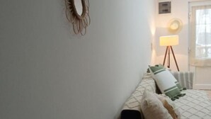 Ein Schlafzimmer mit einem Bett, einer Lampe und einer Wanddekoration.