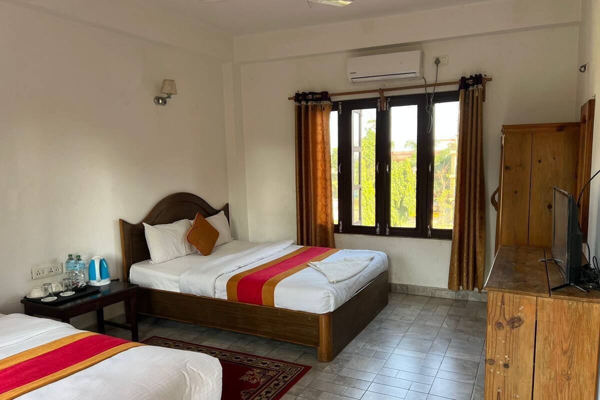 A hotel room with a bed, bedside table, and a TV.