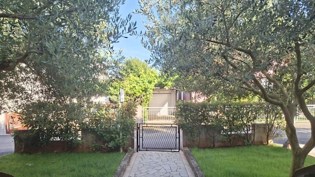 A paved pathway leading to a gated entrance, surrounded by lush greenery and trees. - Stefanija Residence Umag (Umag)