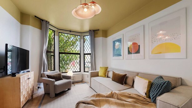 A modern living room with a sofa, armchair, and a television on a wooden cabinet. - Evershot Rd N4, Crouch Hill, Finsbury Park (London)
